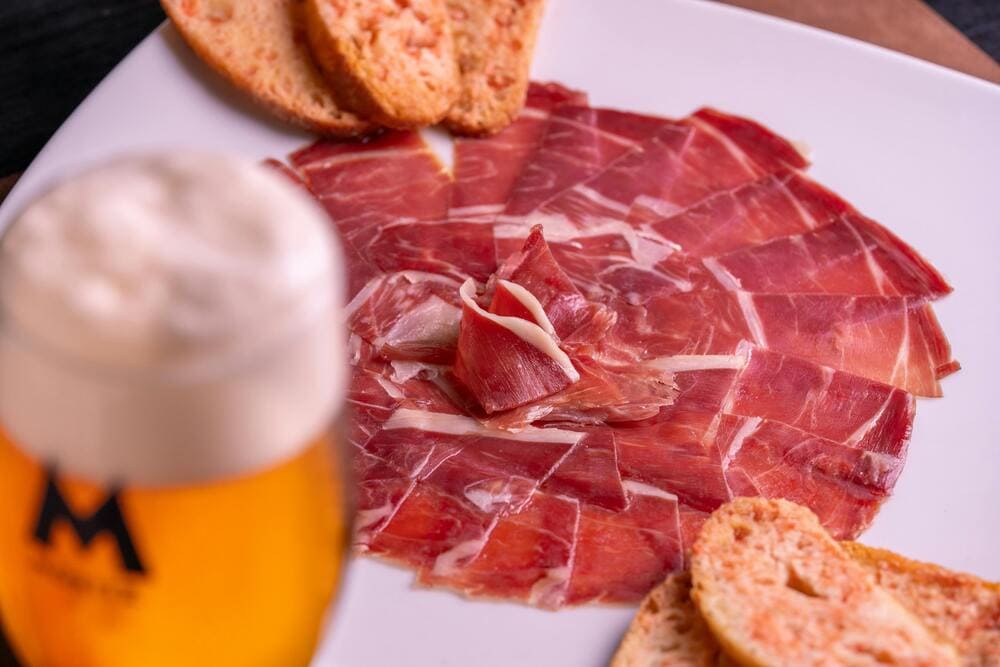 plato de jamón ibérico con pan con tomate y cerveza.